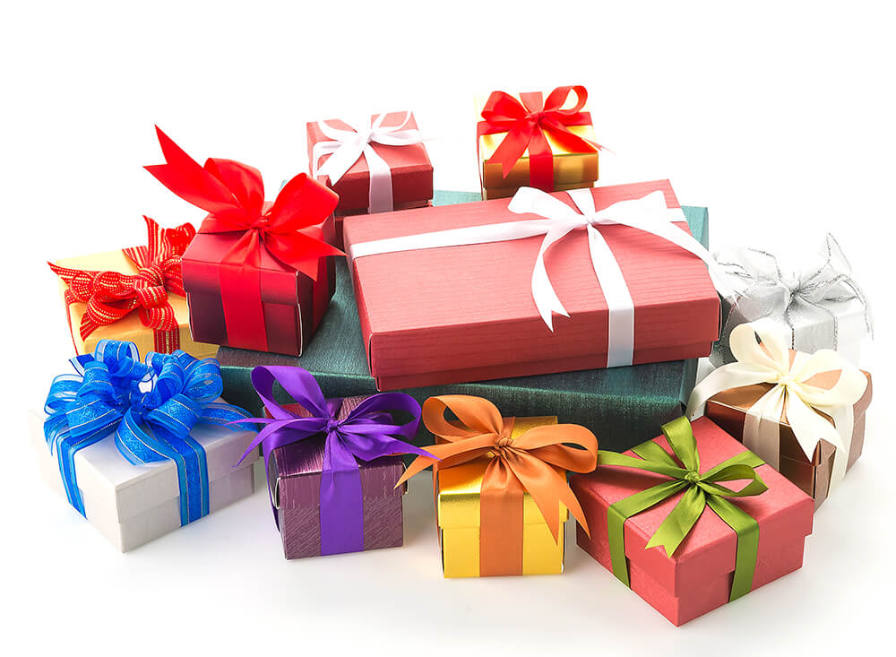 A colorful assortment of neatly wrapped gift boxes with vibrant ribbons, stacked together on a clean white background for celebration.