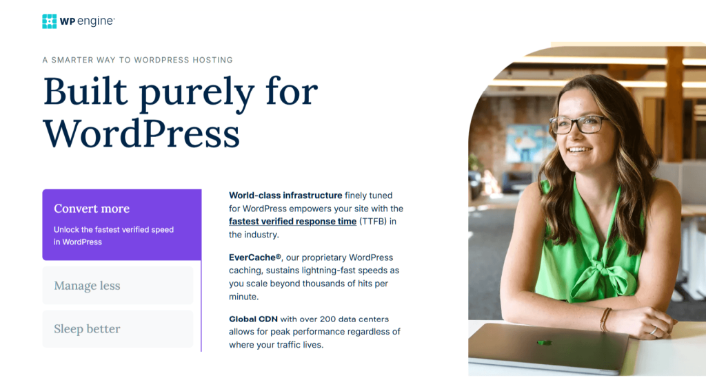 Smiling woman in a green blouse sits at a desk with a closed laptop, representing a professional, modern WordPress hosting office setting.